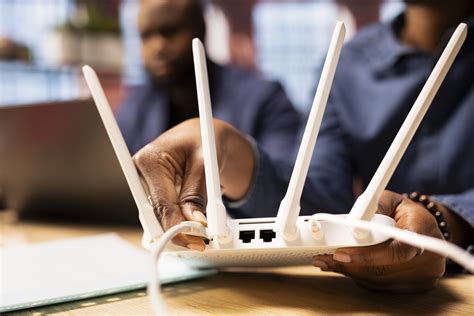 A person rebooting their modem and router in a home office setting.