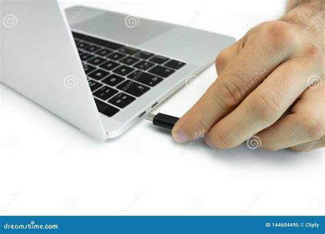 A person plugging in an external hard drive to their laptop.